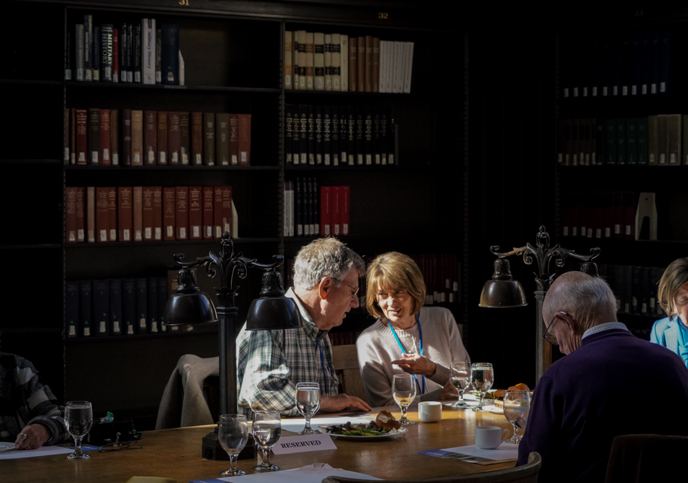 A couple is bathed in window light while seated at a table with their meals